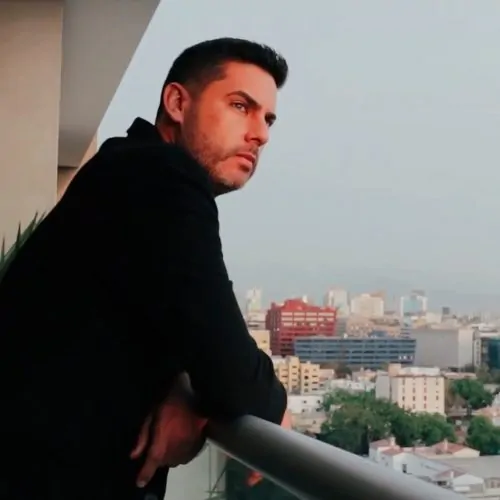 Pedro Castre, mentor y creador del curso Certificación Libertad Financiera, observando el horizonte desde un balcón, representando la visión de éxito y gestión patrimonial